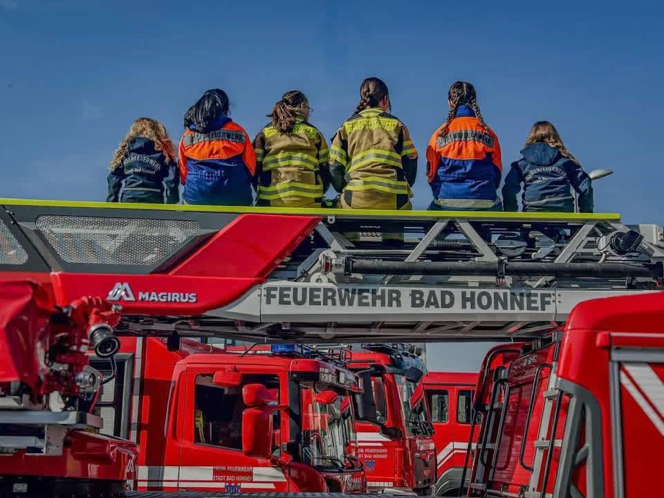 Angehörige der Feuerwehr Bad Honnef auf der Drehleiter über den Feuerwehrfahrzeugen